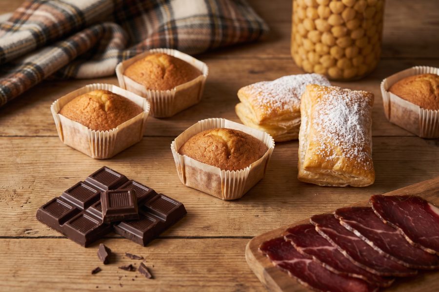 Mantecadas, hojaldres, chocolate y cecina, productos típicos de Astorga, sobre una mesa de madera
