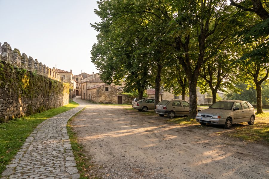 Aparcamiento gratuito bajo los árboles junto a la muralla de una ciudad histórica del noroeste de España
